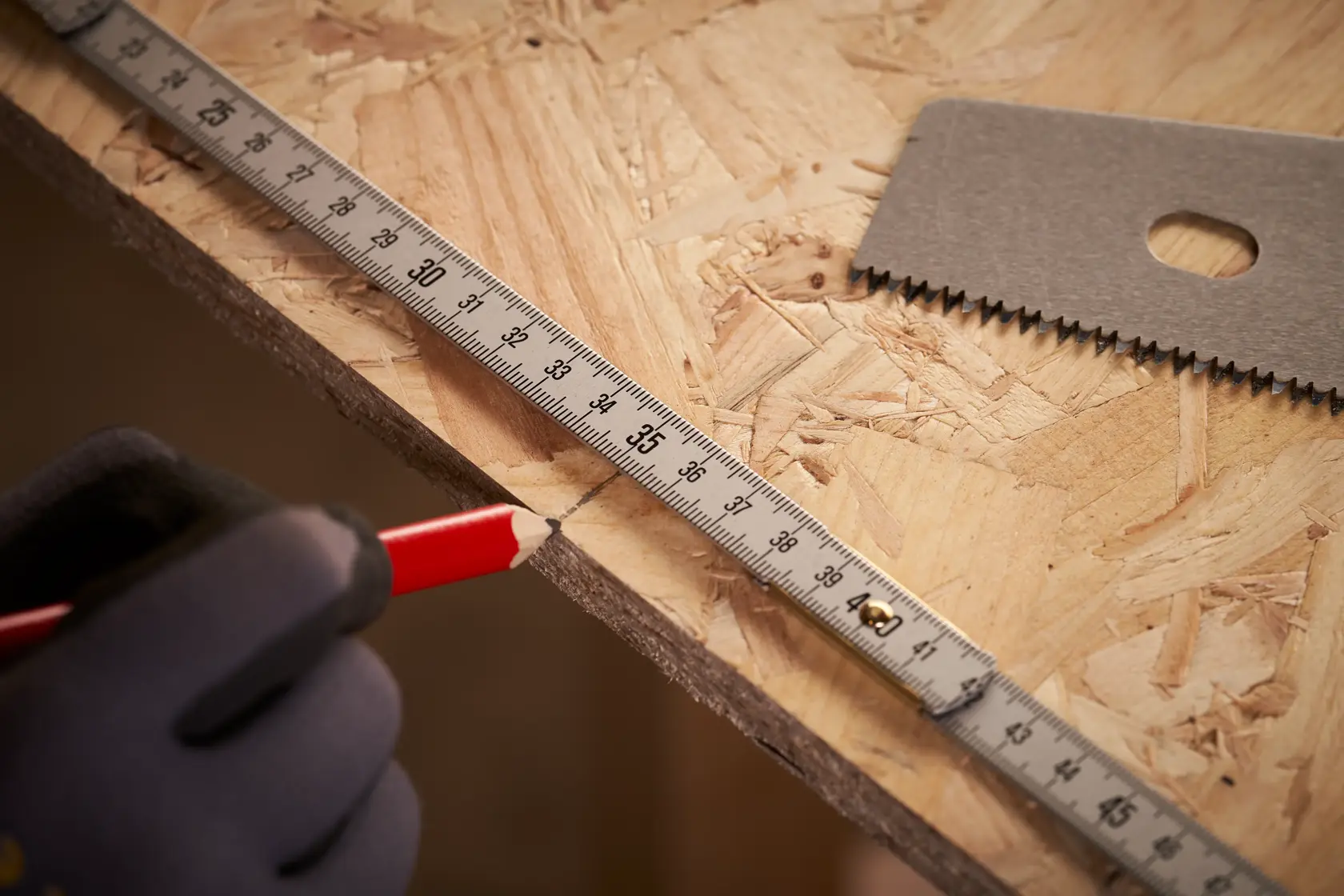 STANLEY 0-35-305 tape measure used to mark wood, close-up showing measurement and cutting tools.