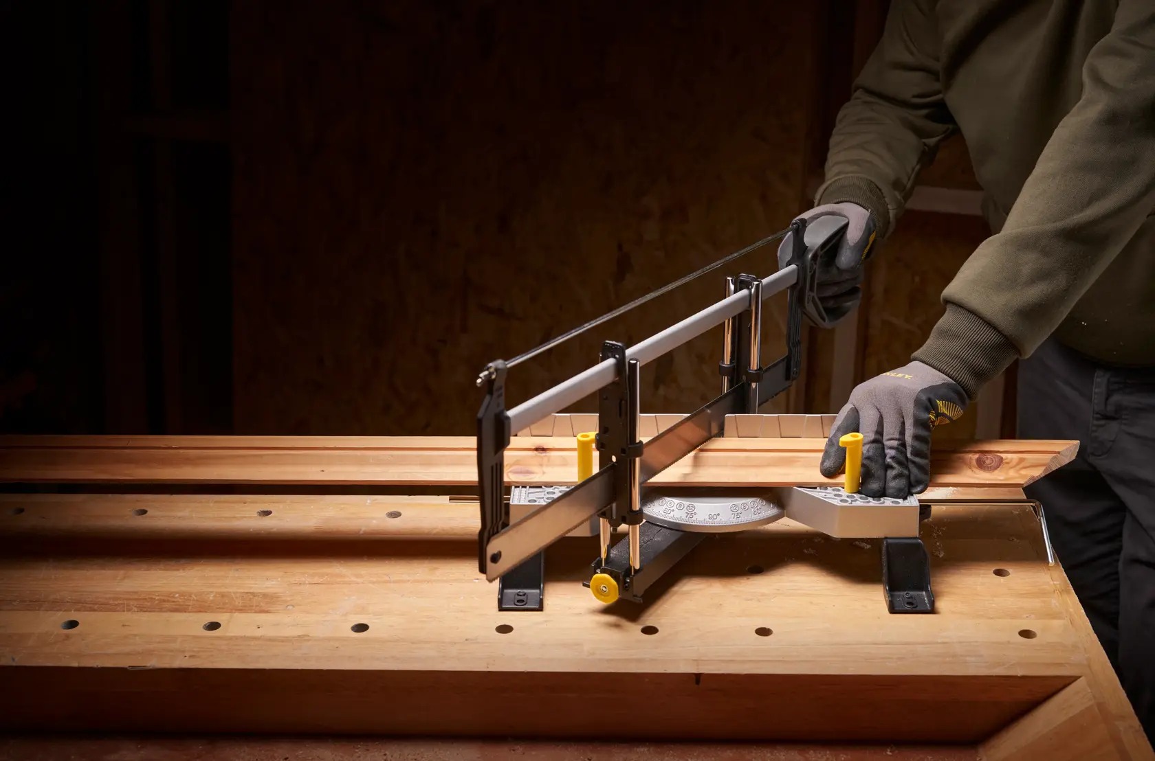 STANLEY 1-20-800 hand mitre saw in use on wooden workbench, cutting angled wood piece.