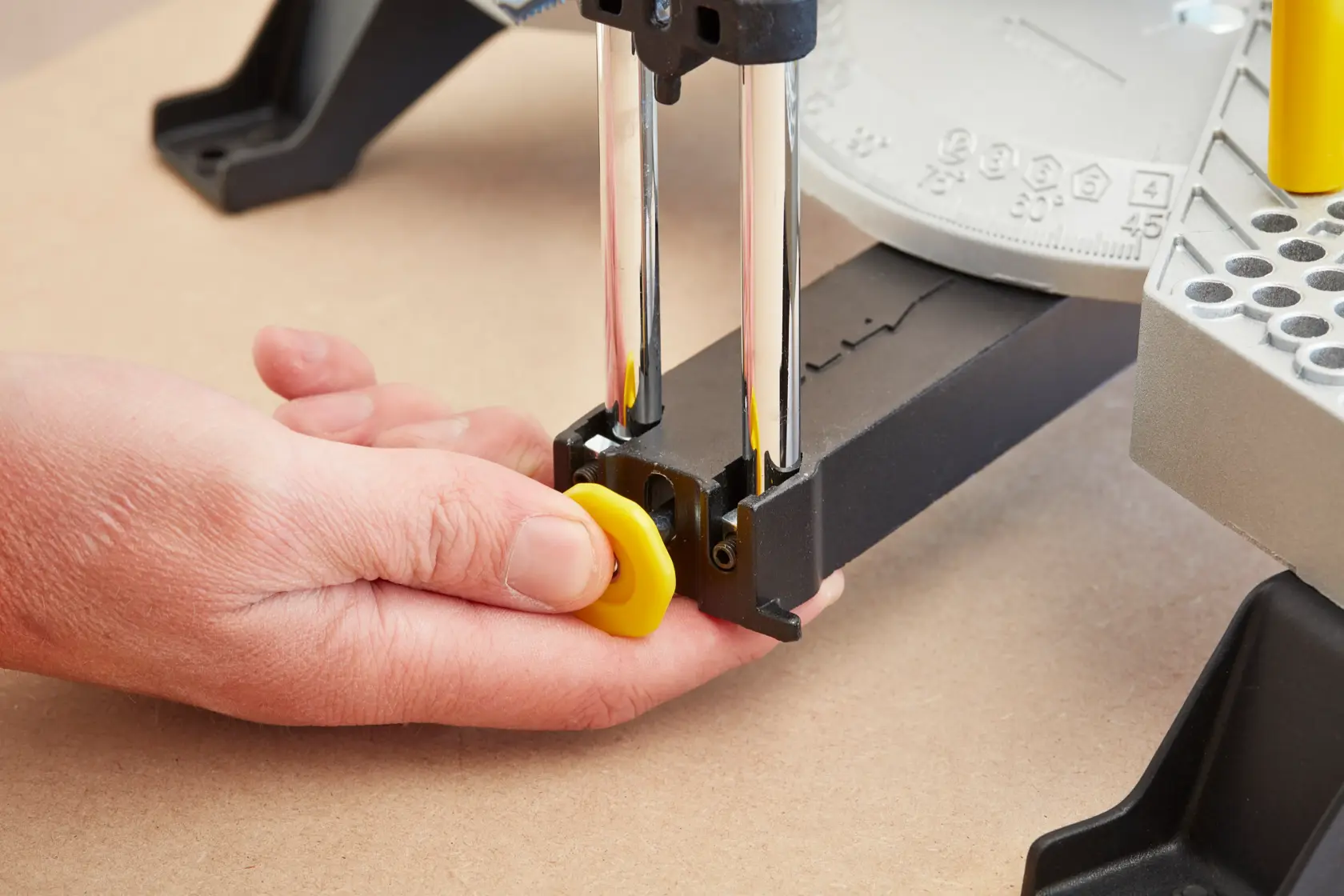 STANLEY 1-20-800 photography of hand adjusting yellow knob on mitre box, close-up angle.