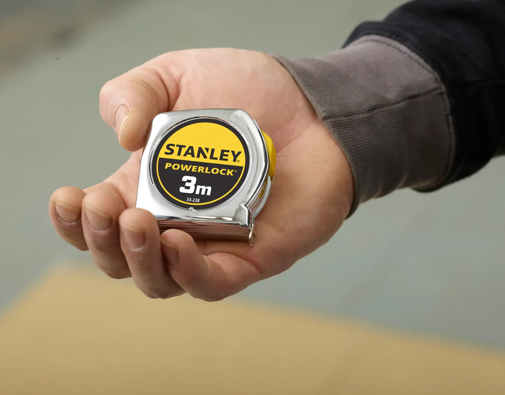 STANLEY 1-33-238 PowerLock tape measure, 3m, silver casing, shown held in hand.