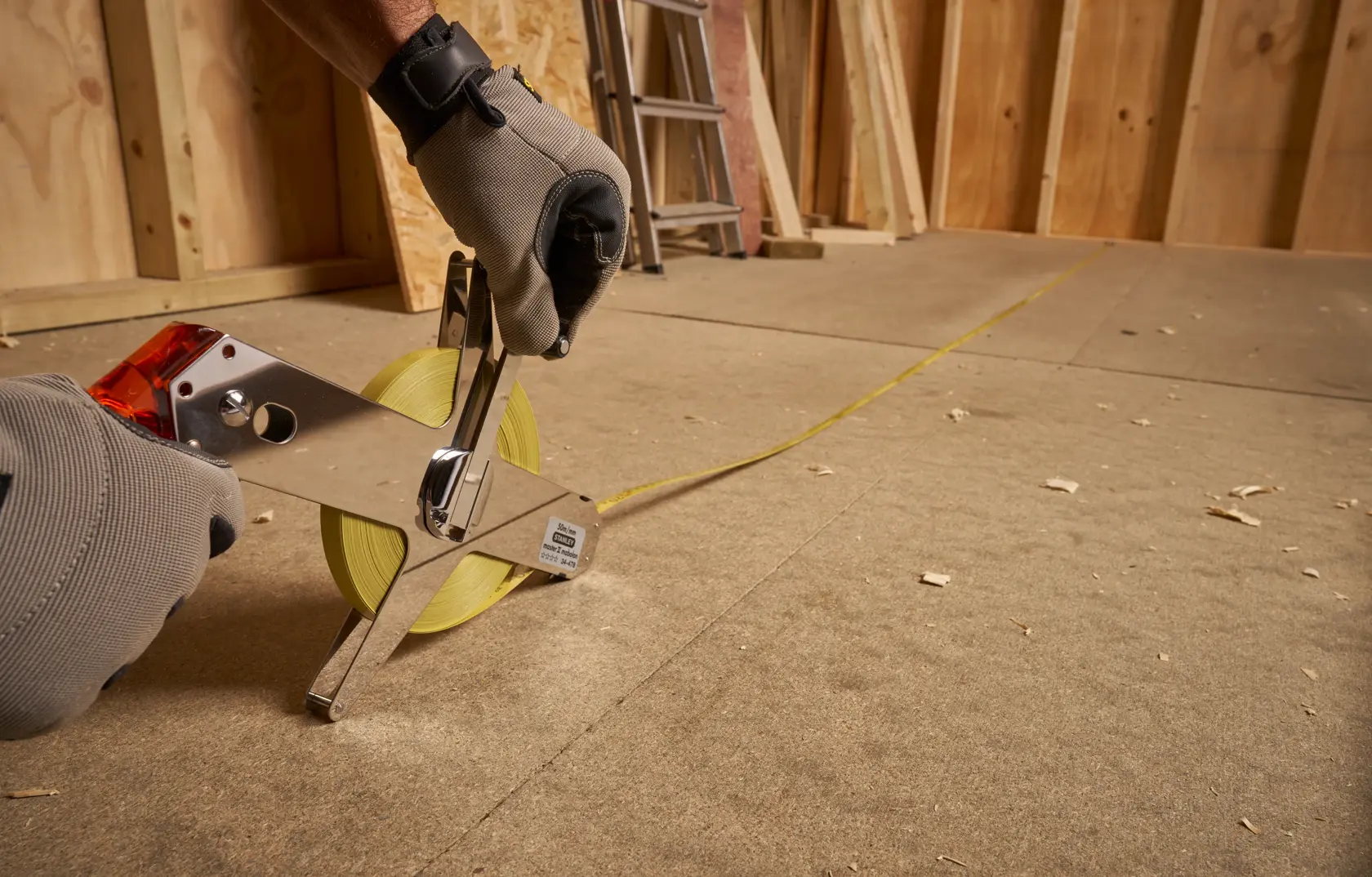 Photo of STANLEY 1-34-478 open reel measuring tape in use on a construction floor.