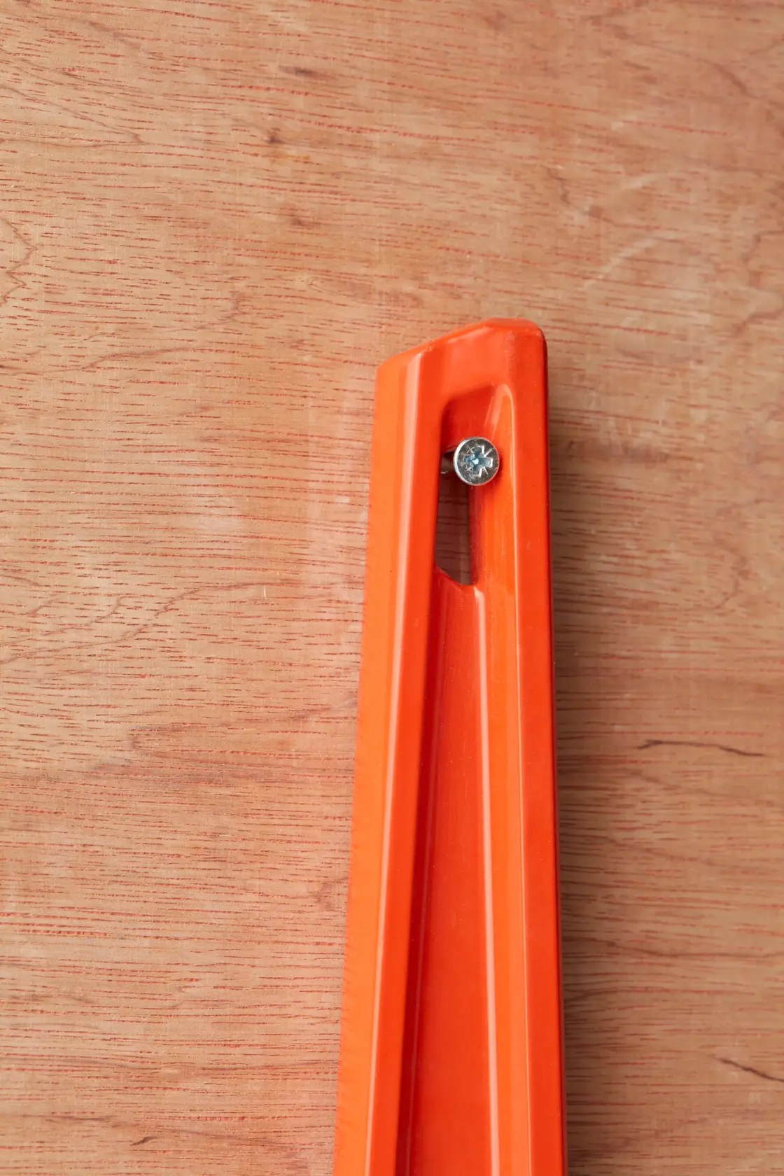 STANLEY 1-42-314 orange spirit level corner close-up photo, fixed with screw on wooden background.