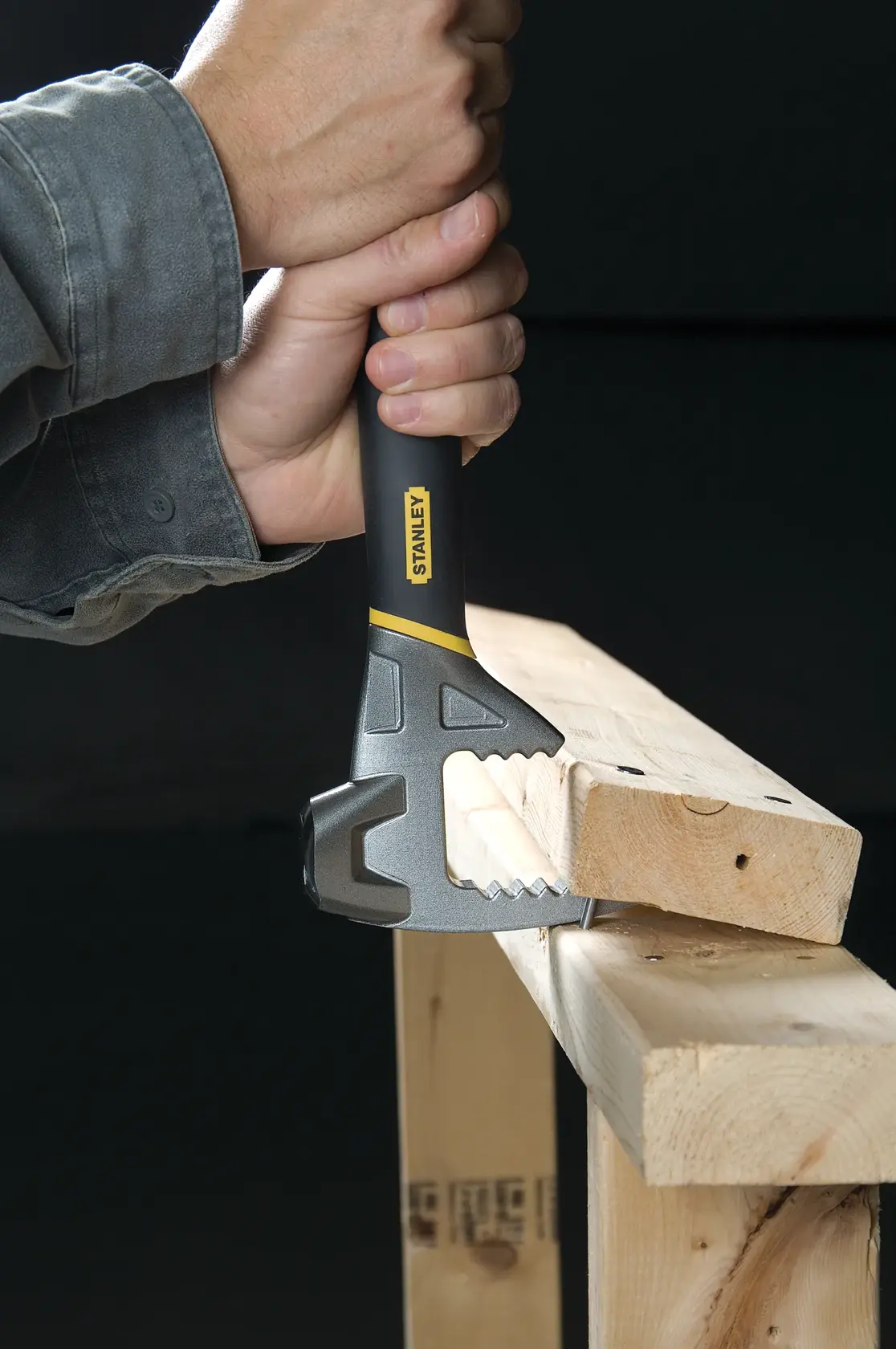 STANLEY 1-55-099 demolition tool held by hand tearing wood, close-up photo.