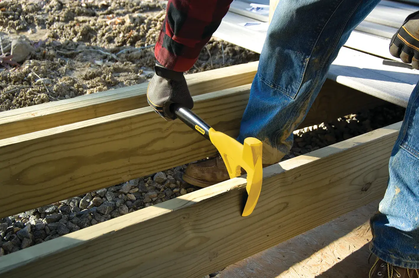 STANLEY 1-55-099 wrecking bar used on wooden beams at construction site, close-up of tool in action.