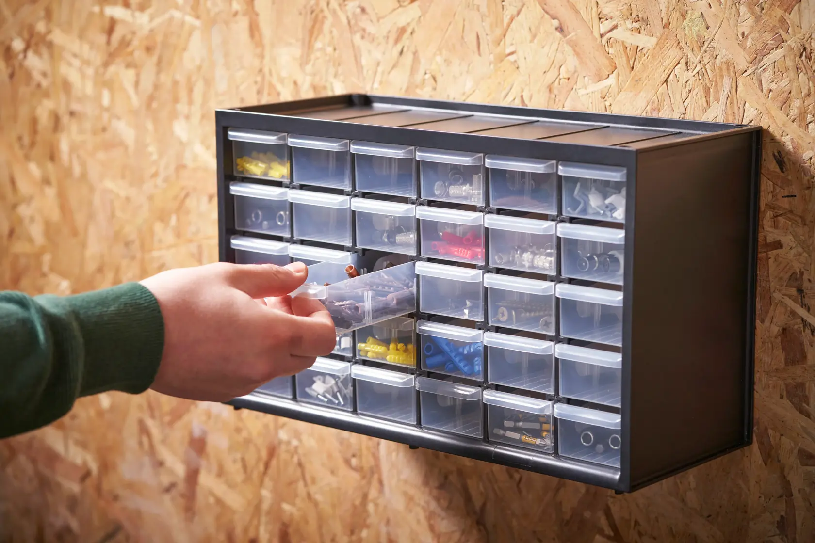 STANLEY 1-93-980 organizer with transparent drawers mounted on wall, hand accessing contents.