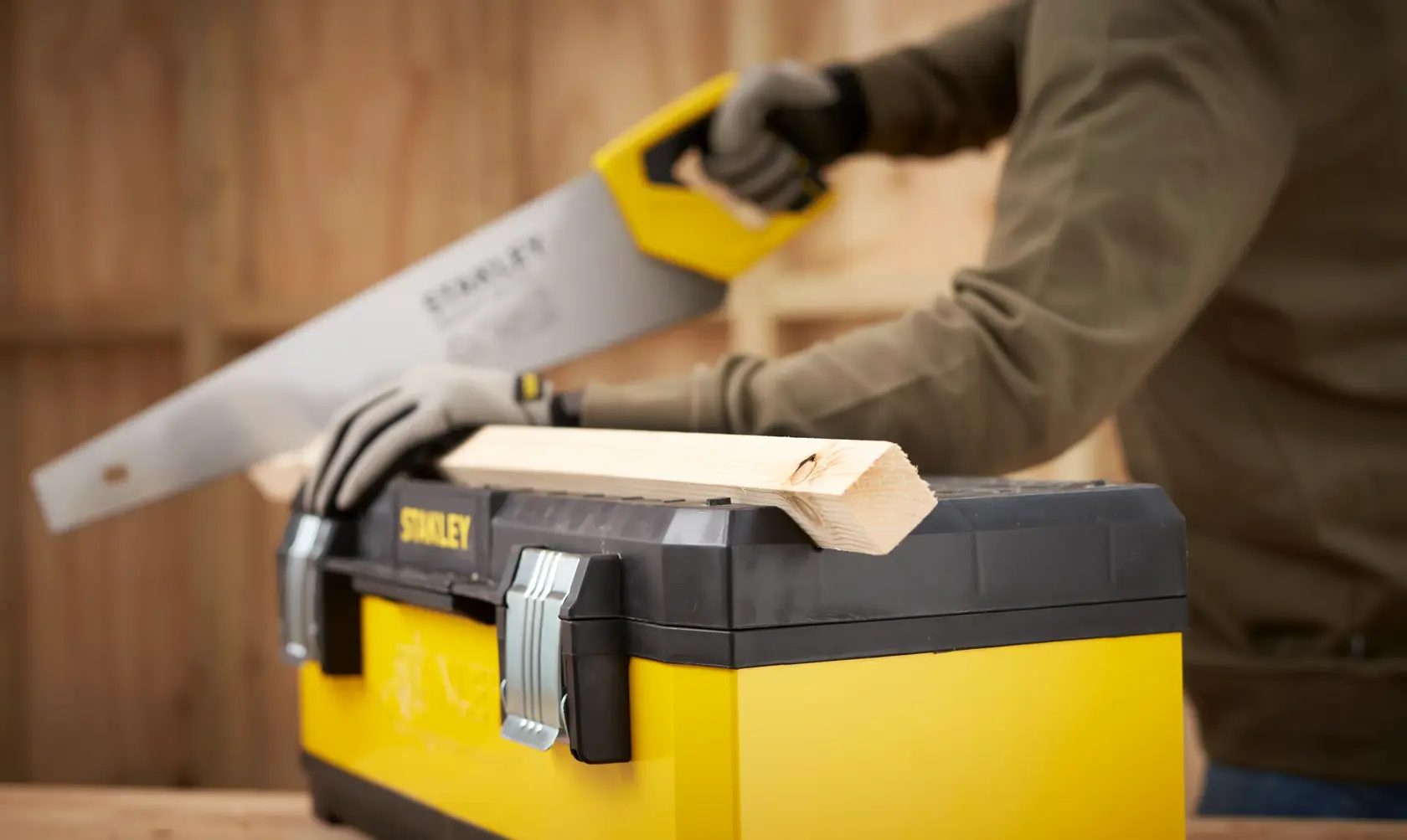 STANLEY 1-95-614 toolbox in use with wood being cut, shown from side angle in workshop setting.
