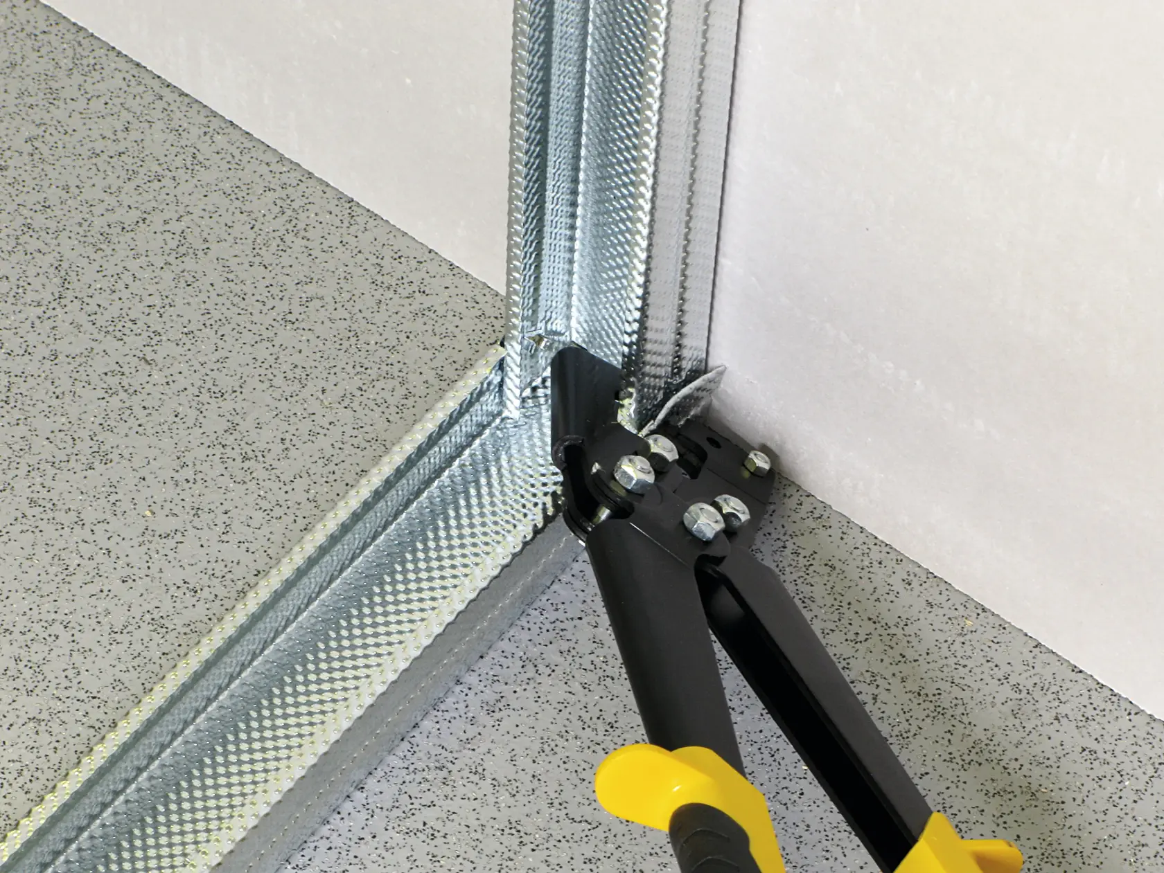 STANLEY 15-273 metal cutting tool in use on steel stud corner, close-up photography.