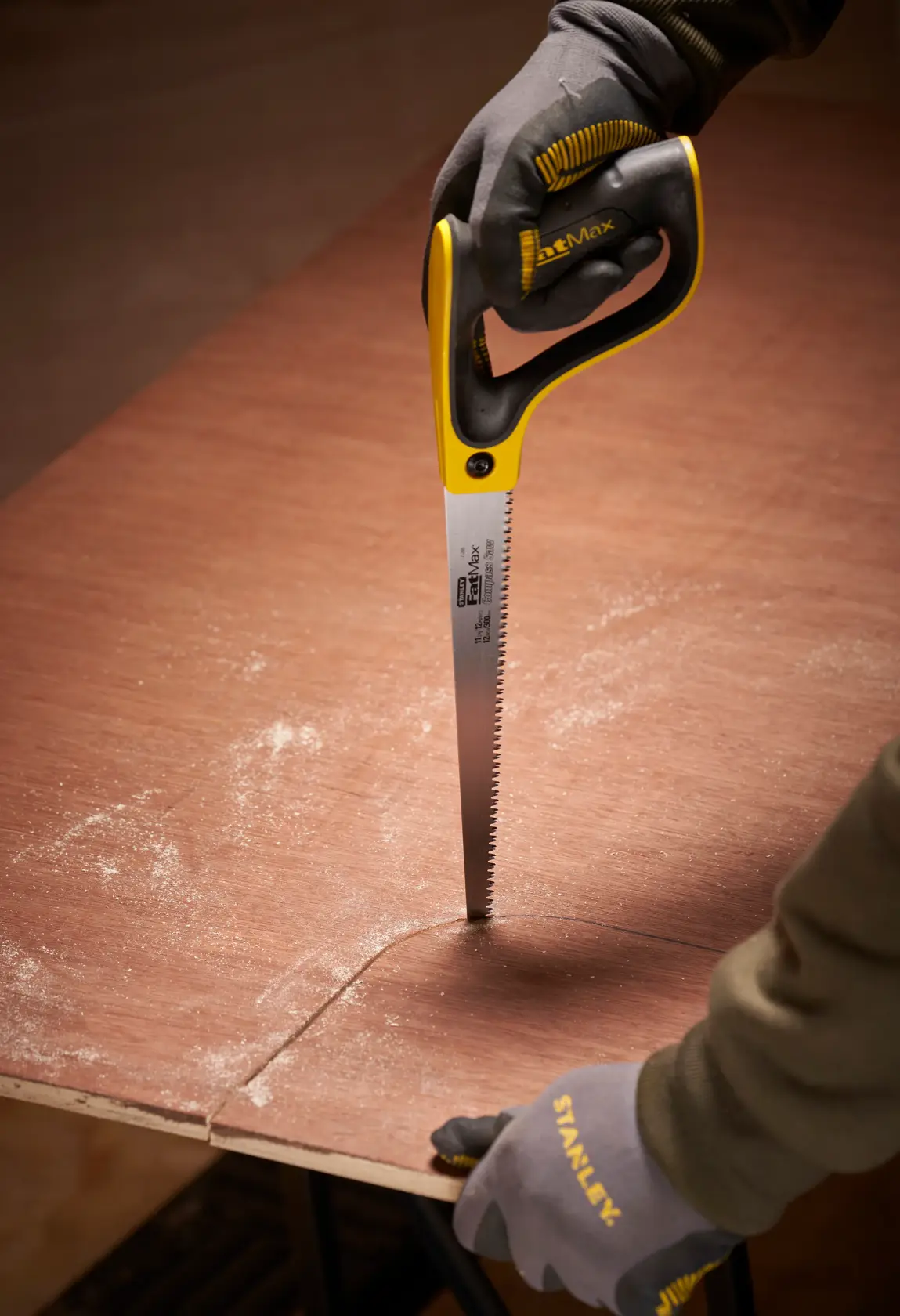 STANLEY 2-17-205 handsaw cutting plywood, close-up photo with gloved hands and curved cut.
