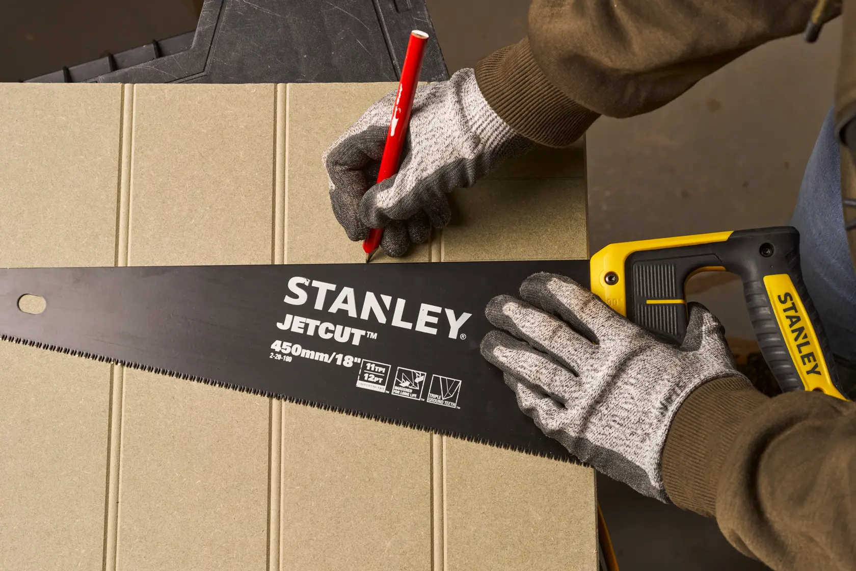 Photography of STANLEY 2-20-180 hand saw with yellow and black handle used for marking cut on board.