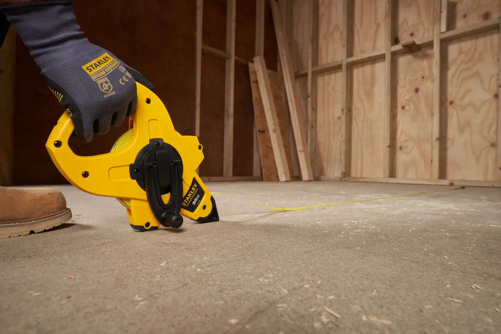 Stanley 2-34-772 open-reel tape measure used for marking lines on a construction floor.