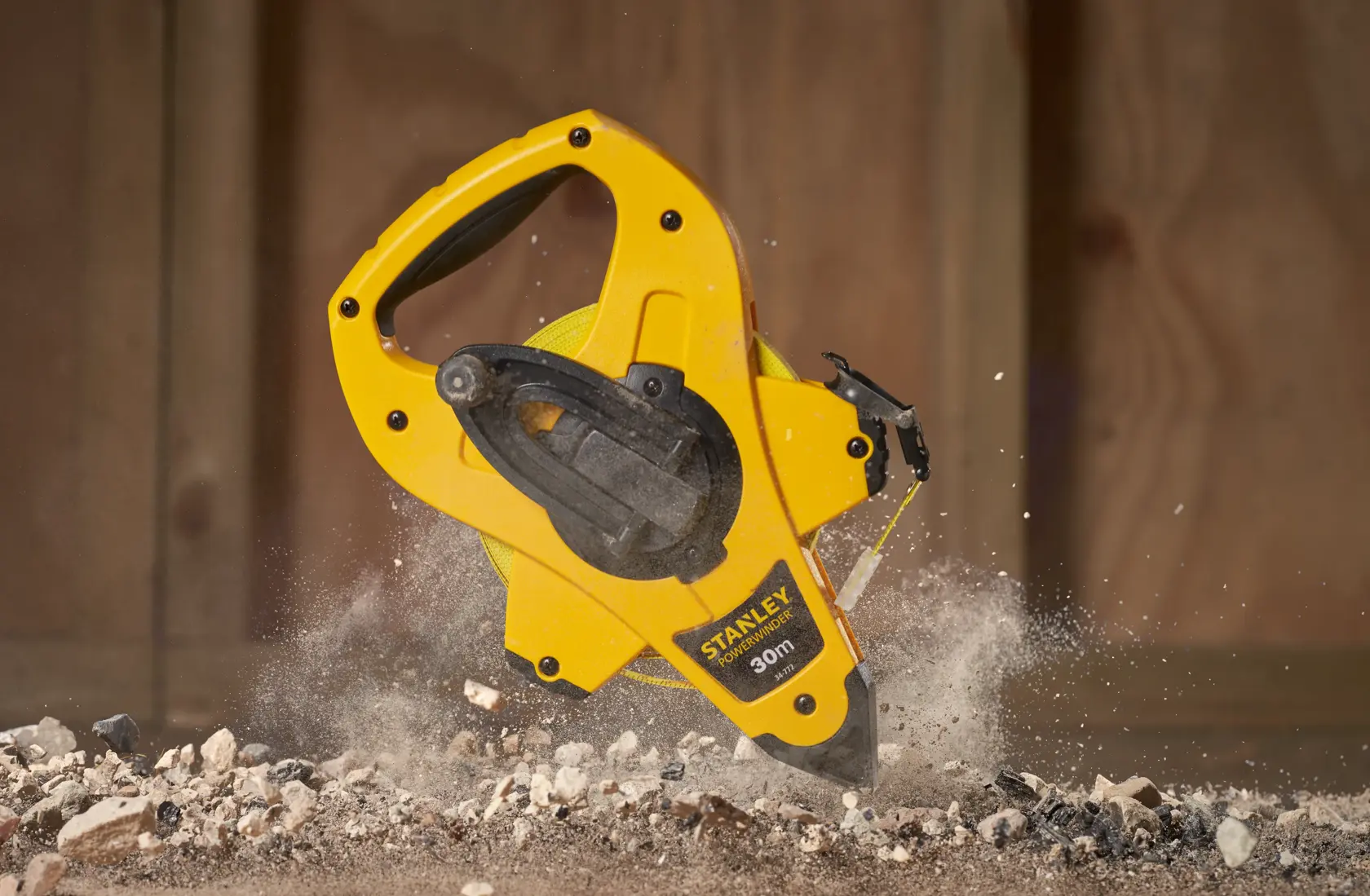 Photo of STANLEY 2-34-772 open reel measuring tape in yellow casing, in use on a construction surface.