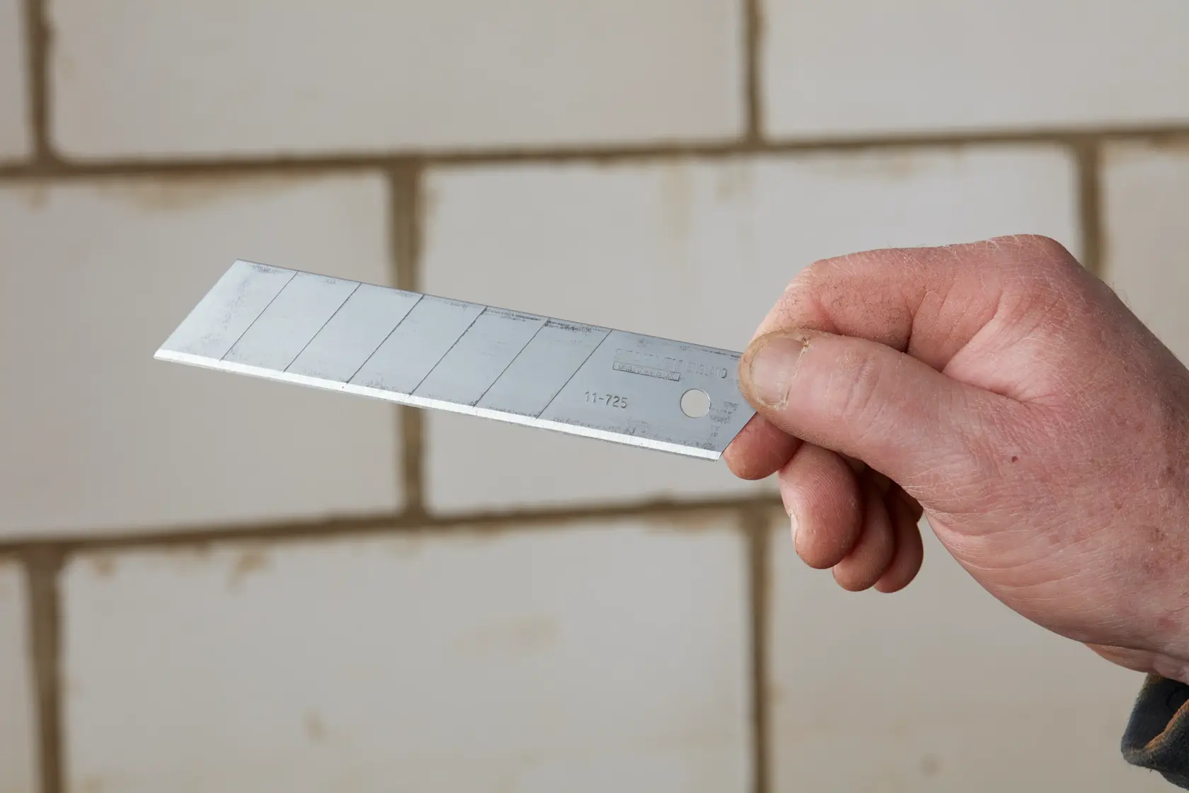 STANLEY 3-11-725 snap-off utility blade held in hand, showing segmented silver steel blade.