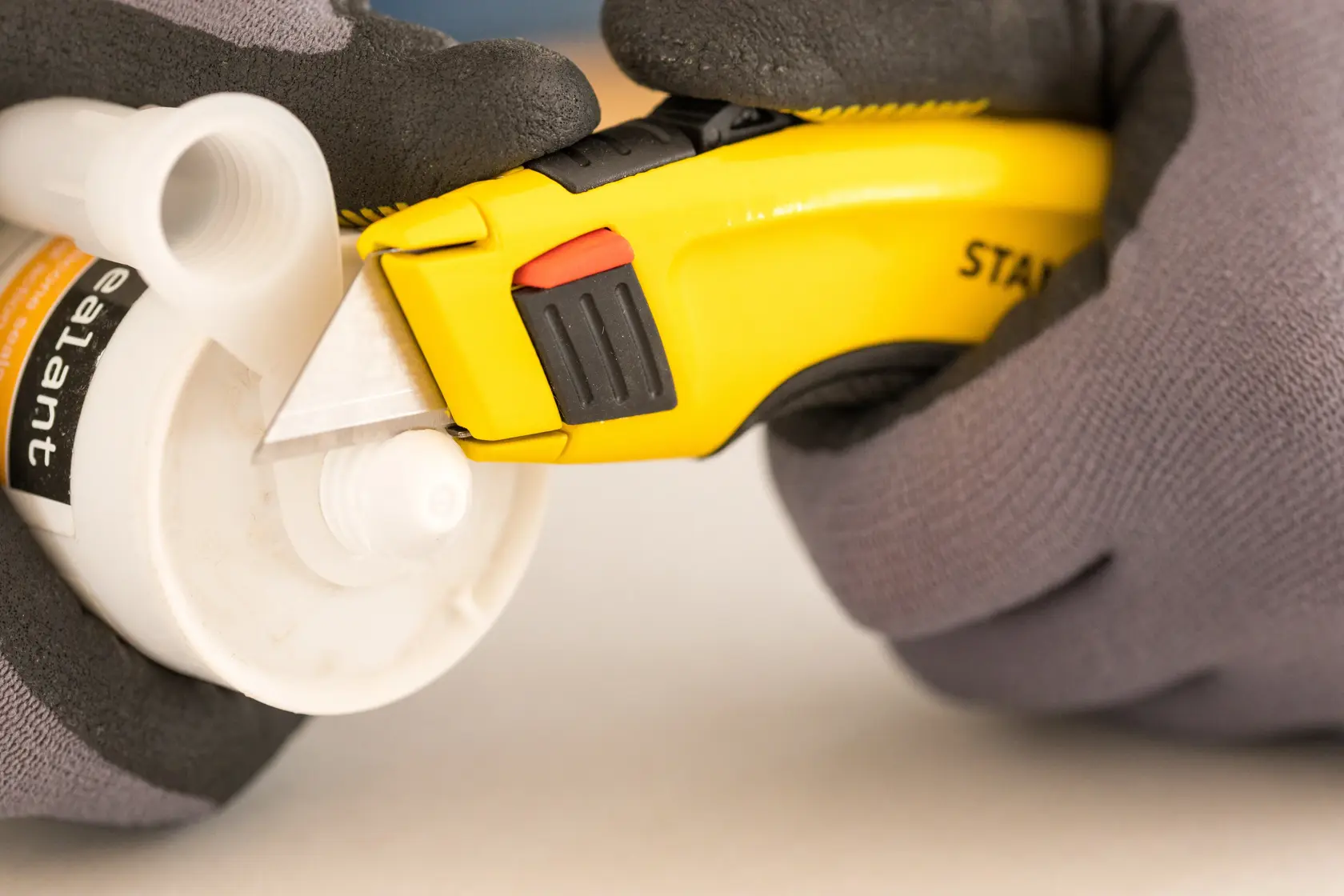STANLEY 7-10-778 utility knife cutting plastic tube, close-up, photography of product in use.