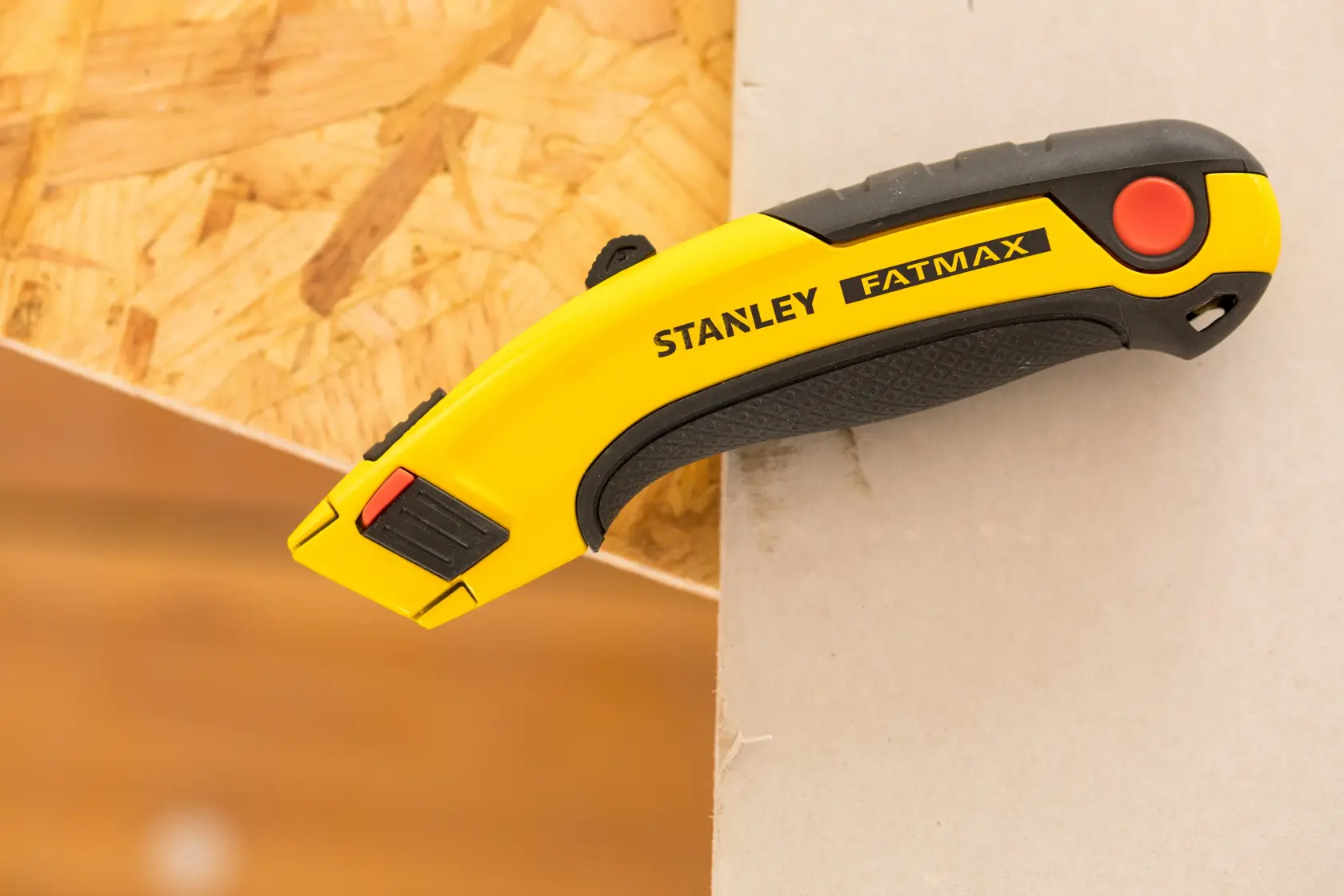 STANLEY 7-10-778 utility knife FATMAX, yellow and black, side angle, on wood and drywall.