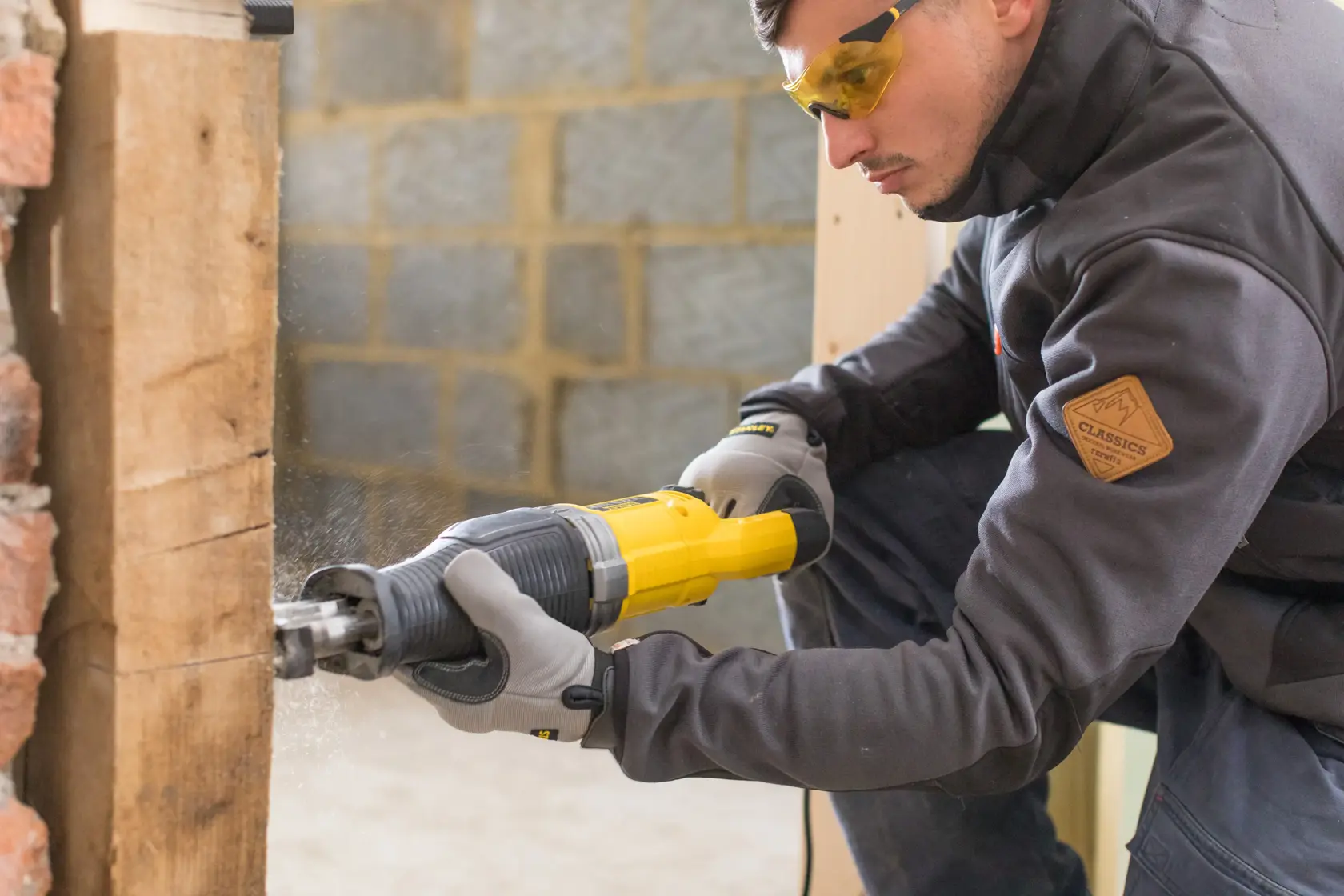 STANLEY FME360 reciprocating saw, yellow and black, used on wood, side angle, power tool photography.