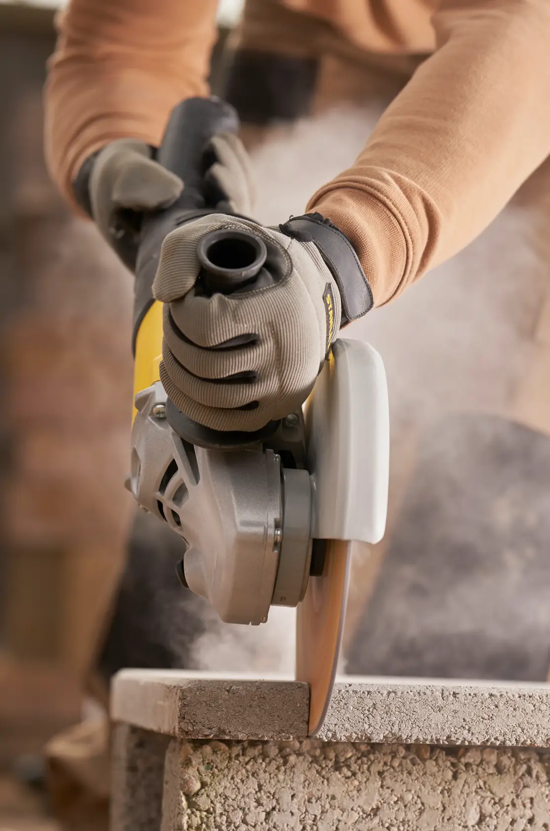 STANLEY FMEG232 angle grinder in use, cutting stone block, close-up photography.