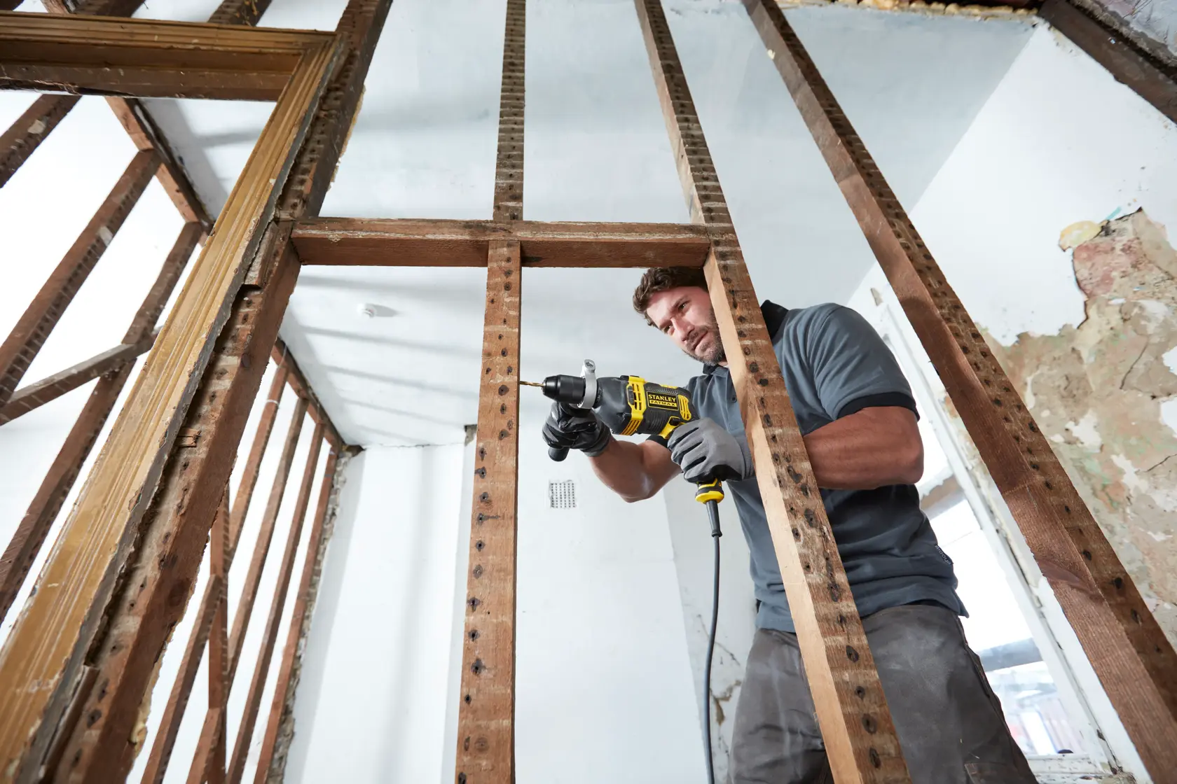 STANLEY FMEH850K drill in use on wooden framing, construction site, close-up side angle.