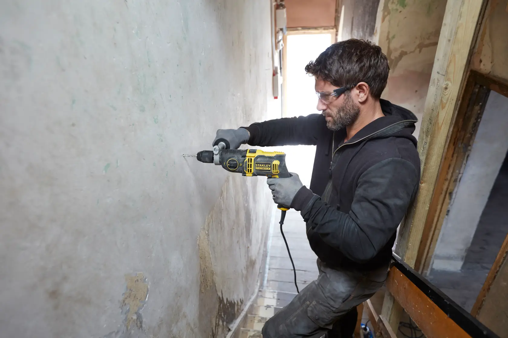 Photo of a person drilling a wall with a STANLEY FMEH850K corded hammer drill.
