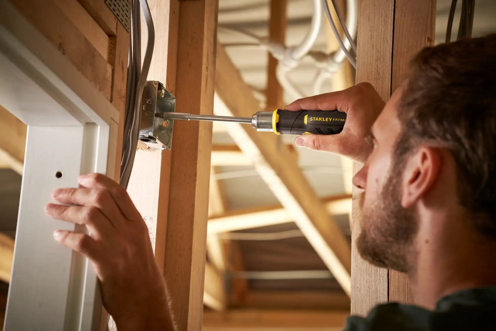 Photo of STANLEY FMHT0-62691 screwdriver in use on electrical junction box, indoor construction setting.