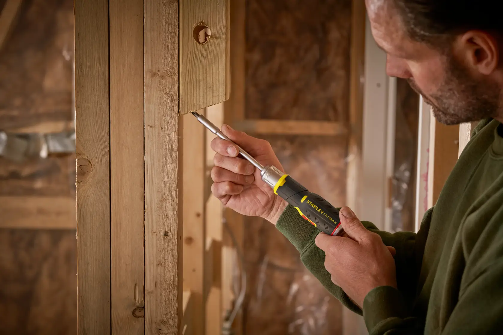 Photo of STANLEY FMHT0-62691 screwdriver used on wooden frame in construction setting.