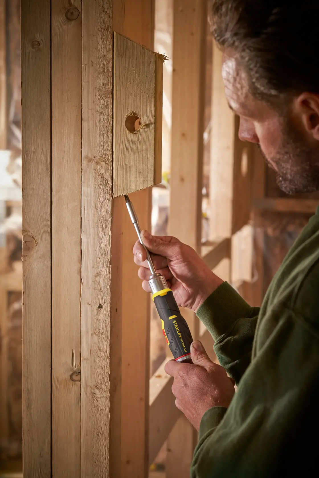 Photo of STANLEY FMHT0-62691 ratcheting screwdriver being used to fasten a screw into wooden framing.