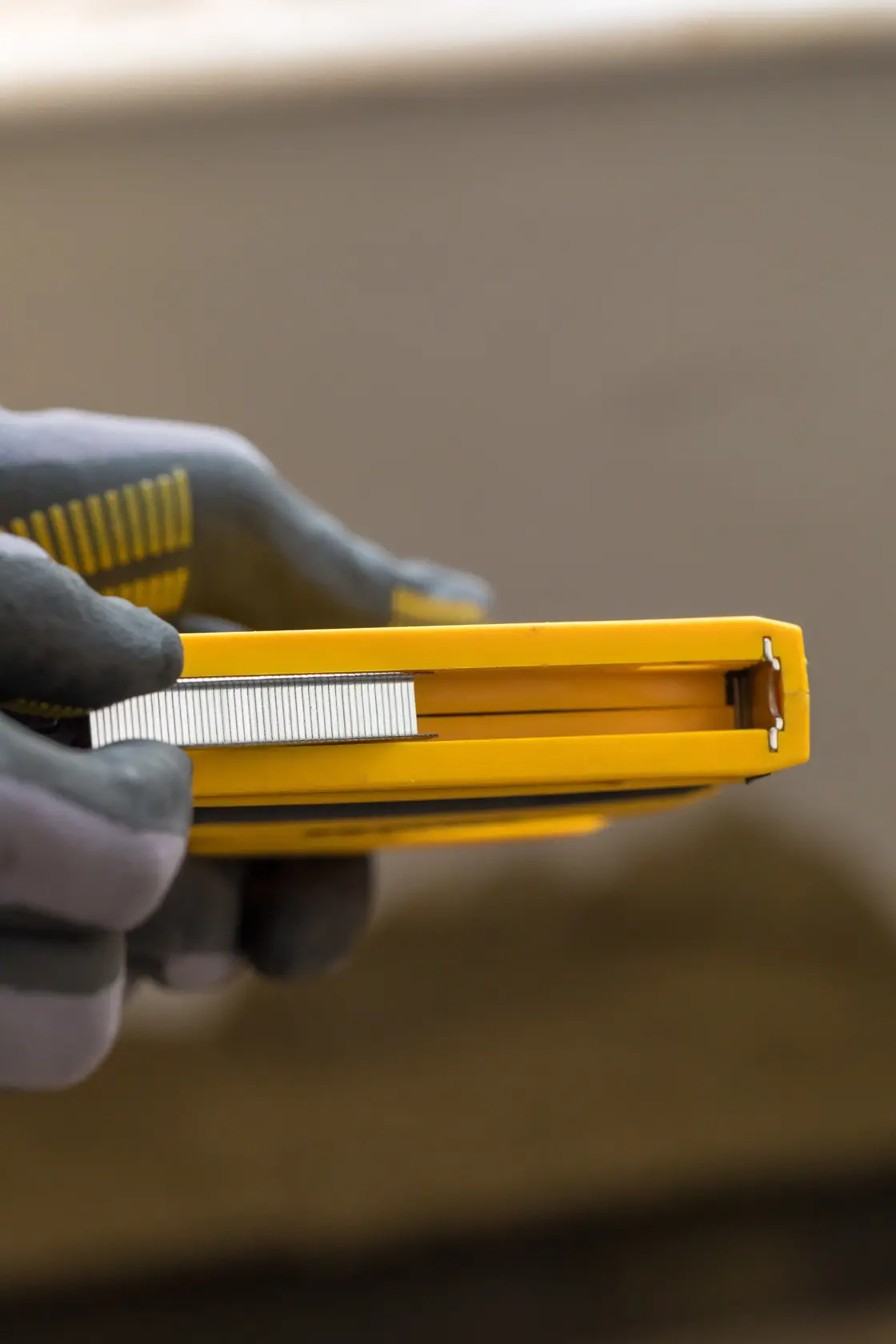 STANLEY FMHT0-80551 stapler held in hand, showing side view and staples inserted.