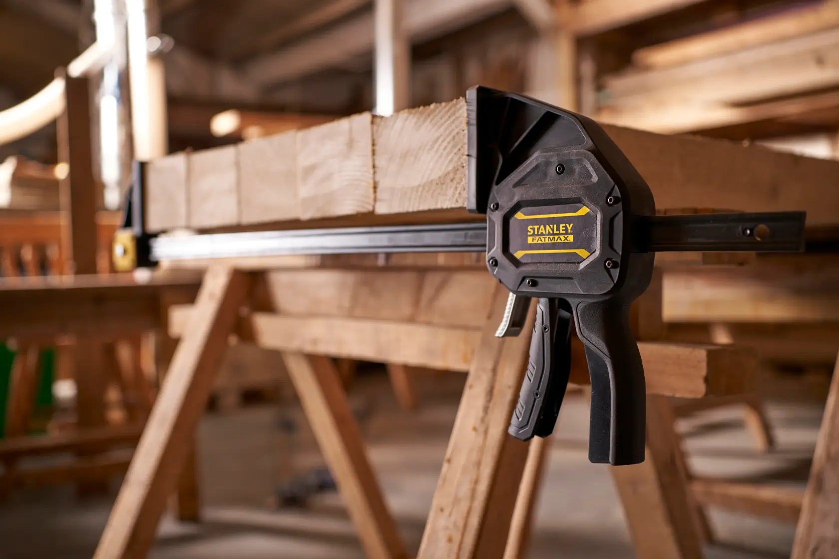STANLEY FMHT0-83240 bar clamp securing wood, side angle, in workshop setting.
