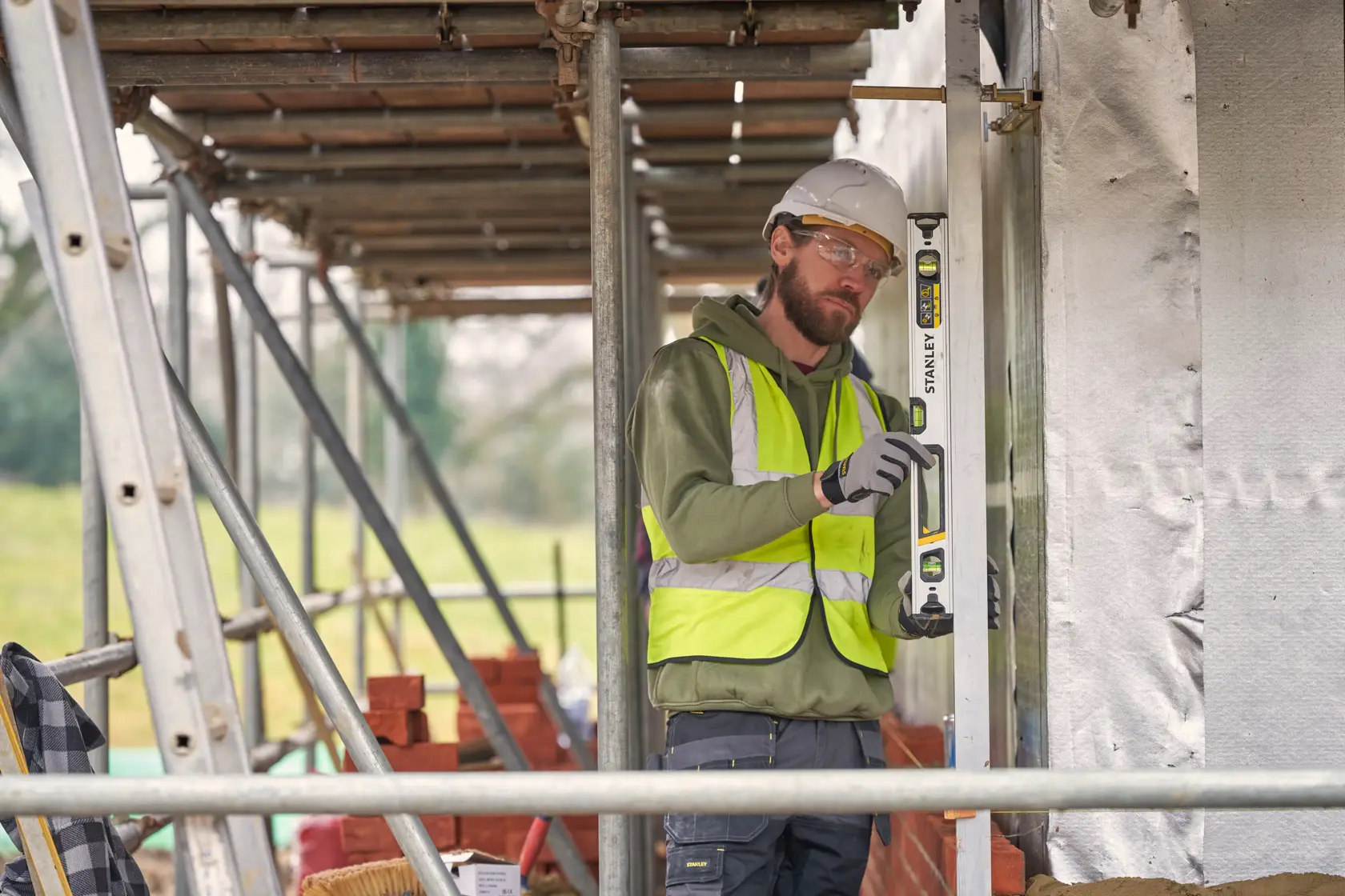STANLEY FMHT43672 spirit level in use by a construction worker at a building site.