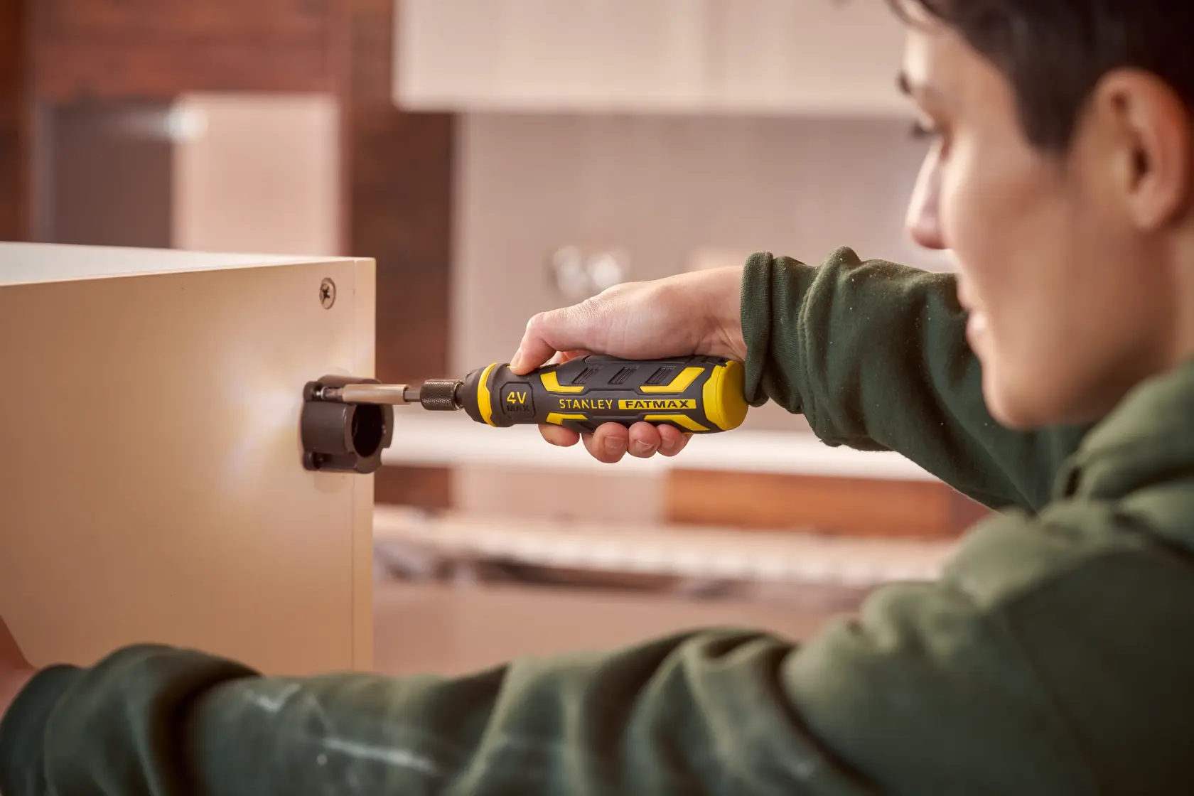Stanley FMHT66719-0 FATMAX cordless screwdriver in use assembling furniture, yellow and black handle.