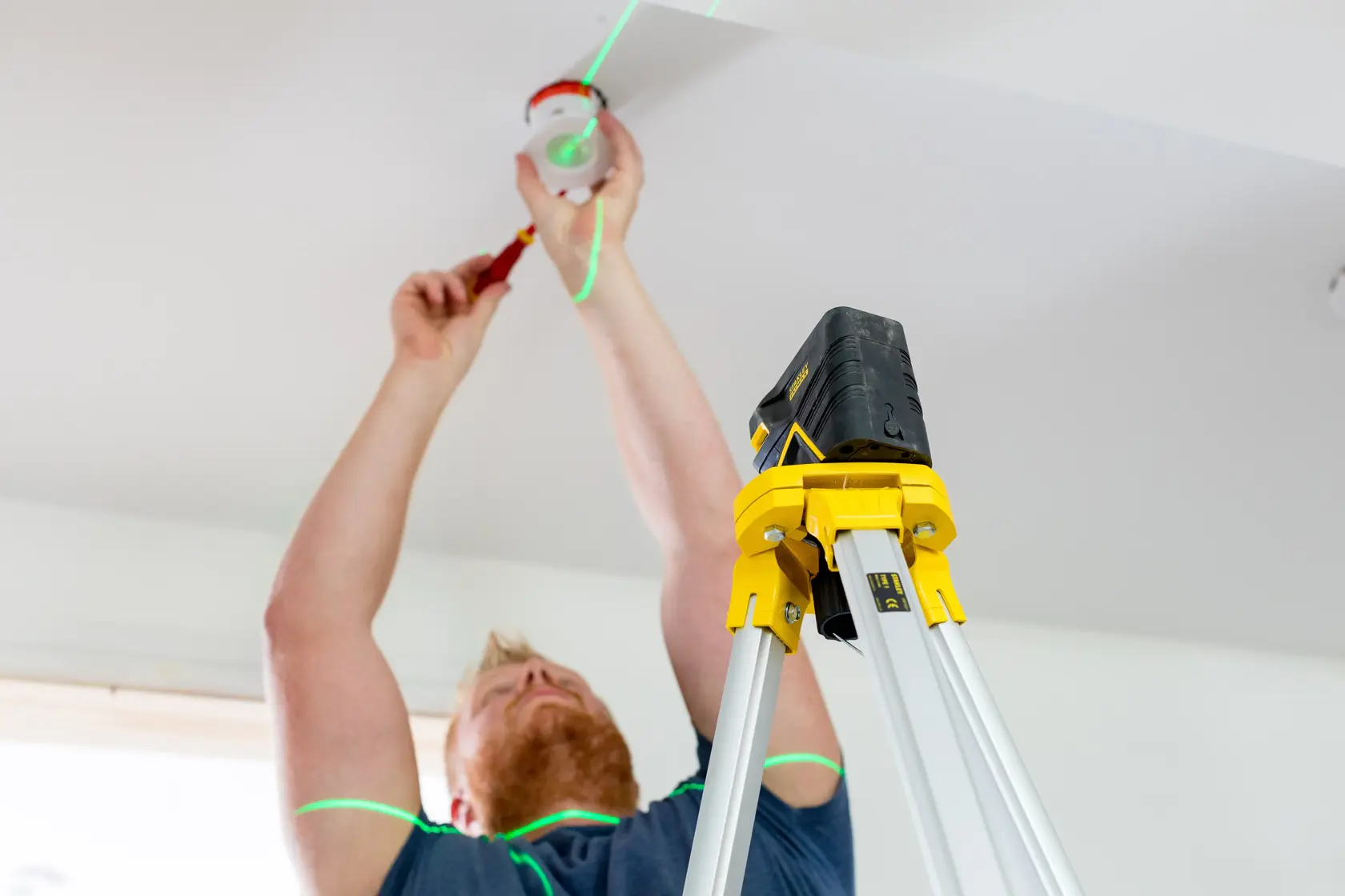 Photo of STANLEY FMHT77598-1 laser level tripod being used for ceiling installation.
