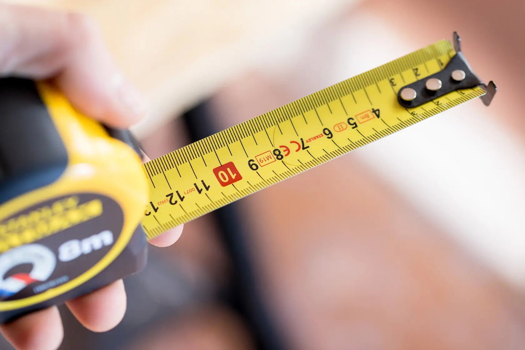 Photo of STANLEY FMHT81555-0 tape measure showing yellow blade with metric markings, close-up view.