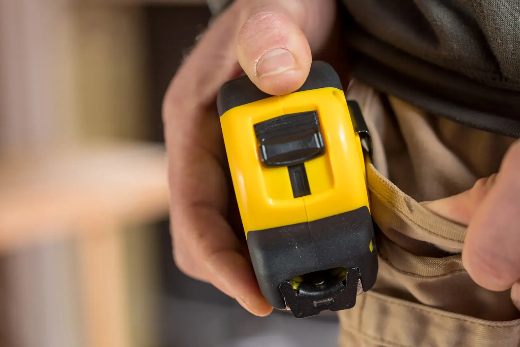 Photo of STANLEY FMHT81555-0 tape measure being clipped to a tool belt, close-up view.
