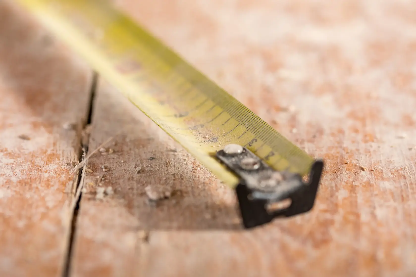 STANLEY FMHT81556-0 yellow tape measure close-up on dusty wooden surface, photography category.
