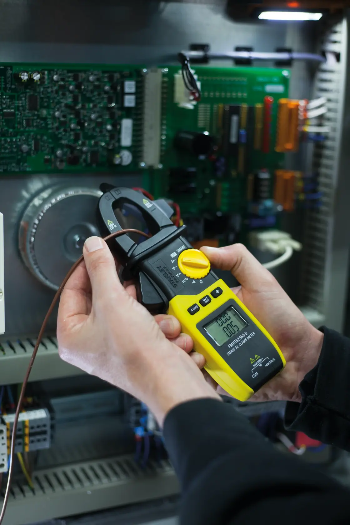 Photo of STANLEY FMHT82564-0 digital clamp meter used to measure current in electrical panel.