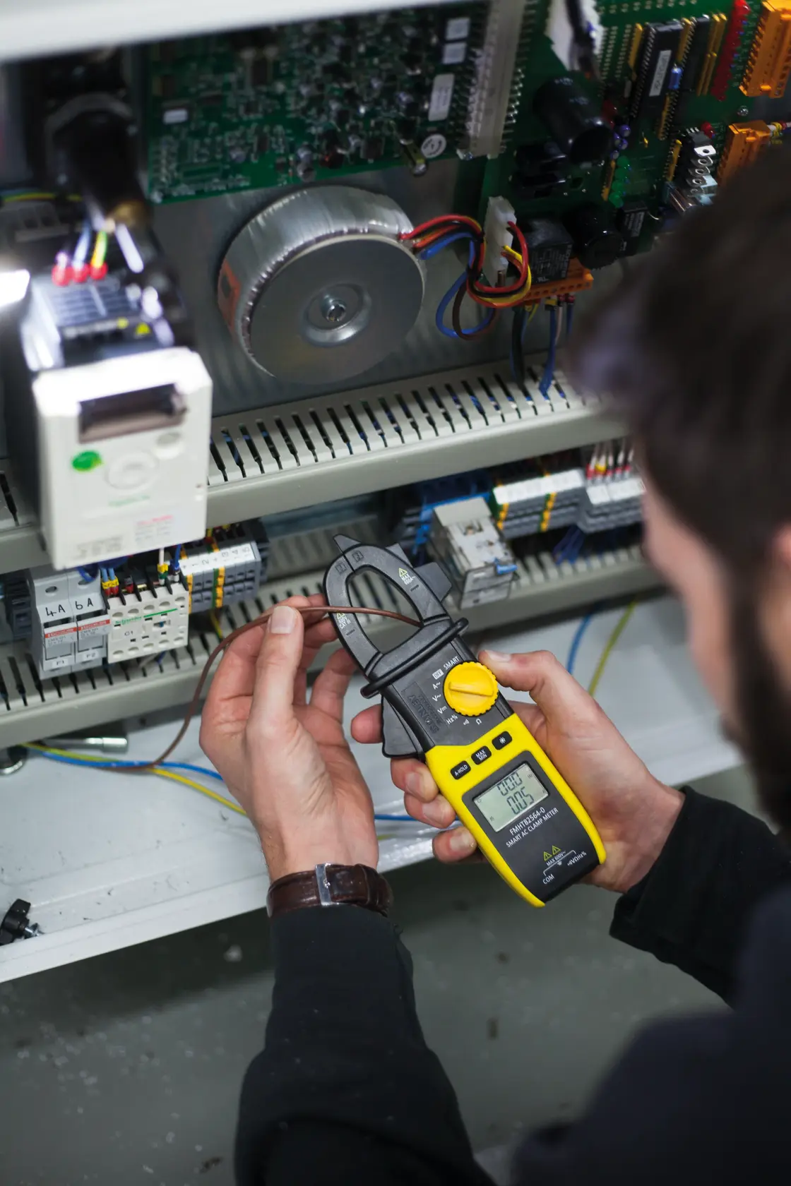 Photo of STANLEY FMHT82564-0 clamp meter in use measuring electrical current in an open control panel.