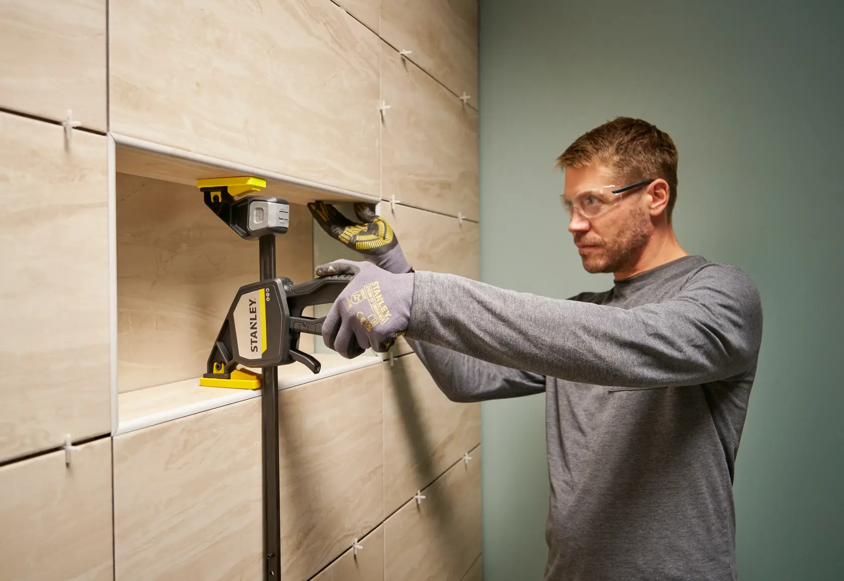 Photo of STANLEY FMHT83279-0 clamp used to hold tiles in place during wall installation.