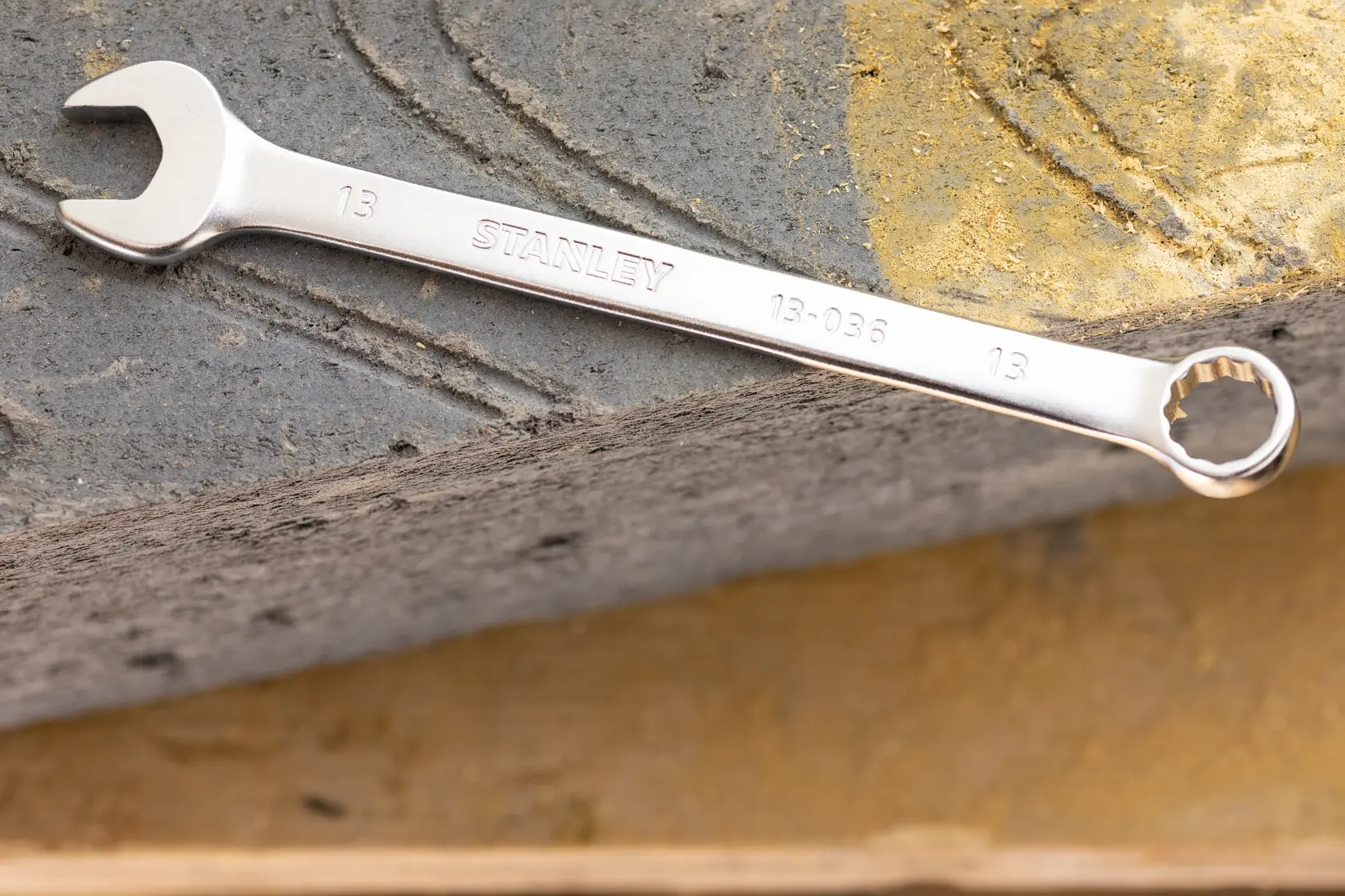 STANLEY FMMT13037-0 combination wrench, silver finish, photographed on a concrete surface.