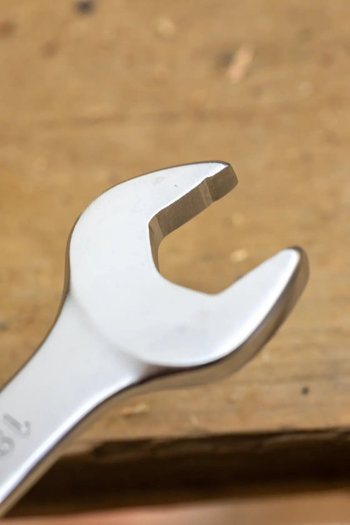 STANLEY FMMT13069-0 open-end wrench close-up on wooden surface, silver finish, hand tool.