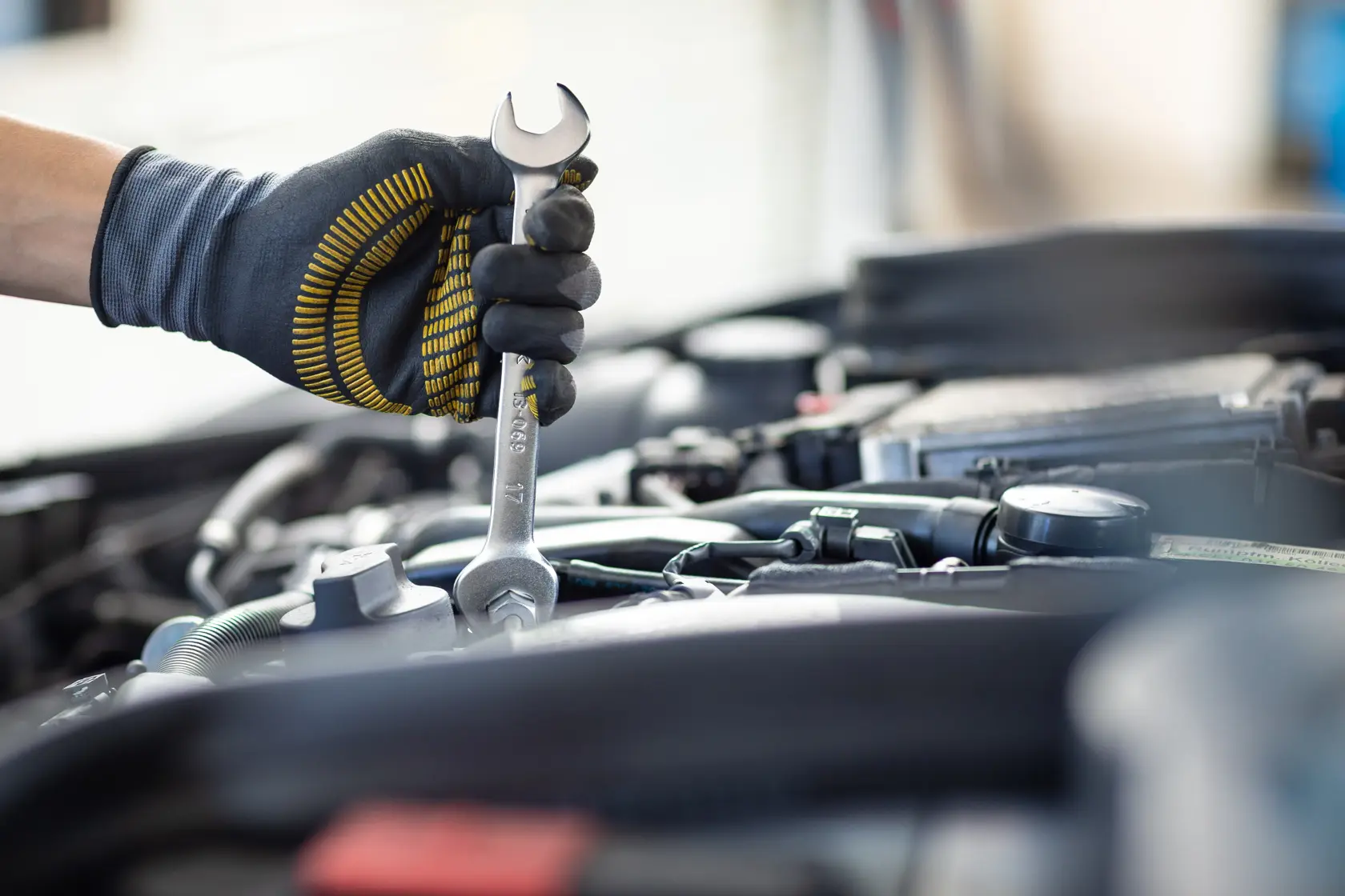 Photo of STANLEY FMMT13072-0 wrench in gloved hand working on car engine, tool details visible.