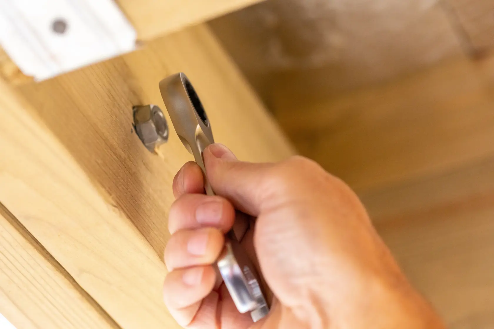Photo of STANLEY FMMT13113-0 ratcheting wrench tightening a nut on a wooden surface.