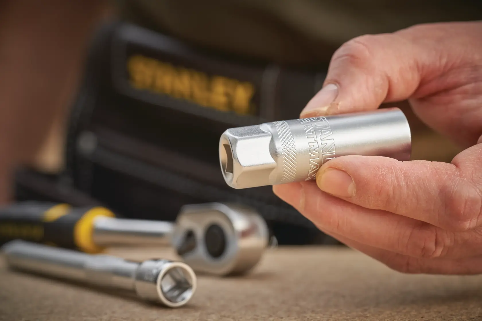 Stanley FMMT17225-0 socket held in hand, with ratchet and socket set on work surface.