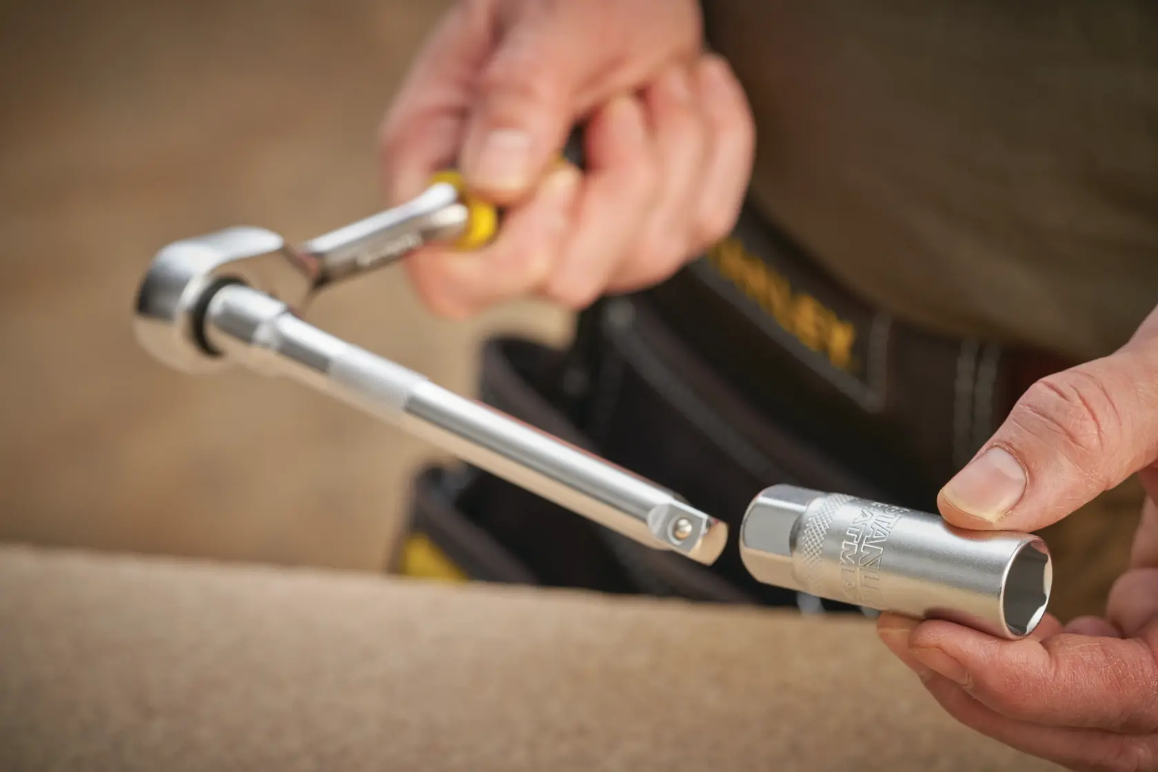 STANLEY FMMT17225-0 socket wrench held by hand with silver socket, close-up photo.