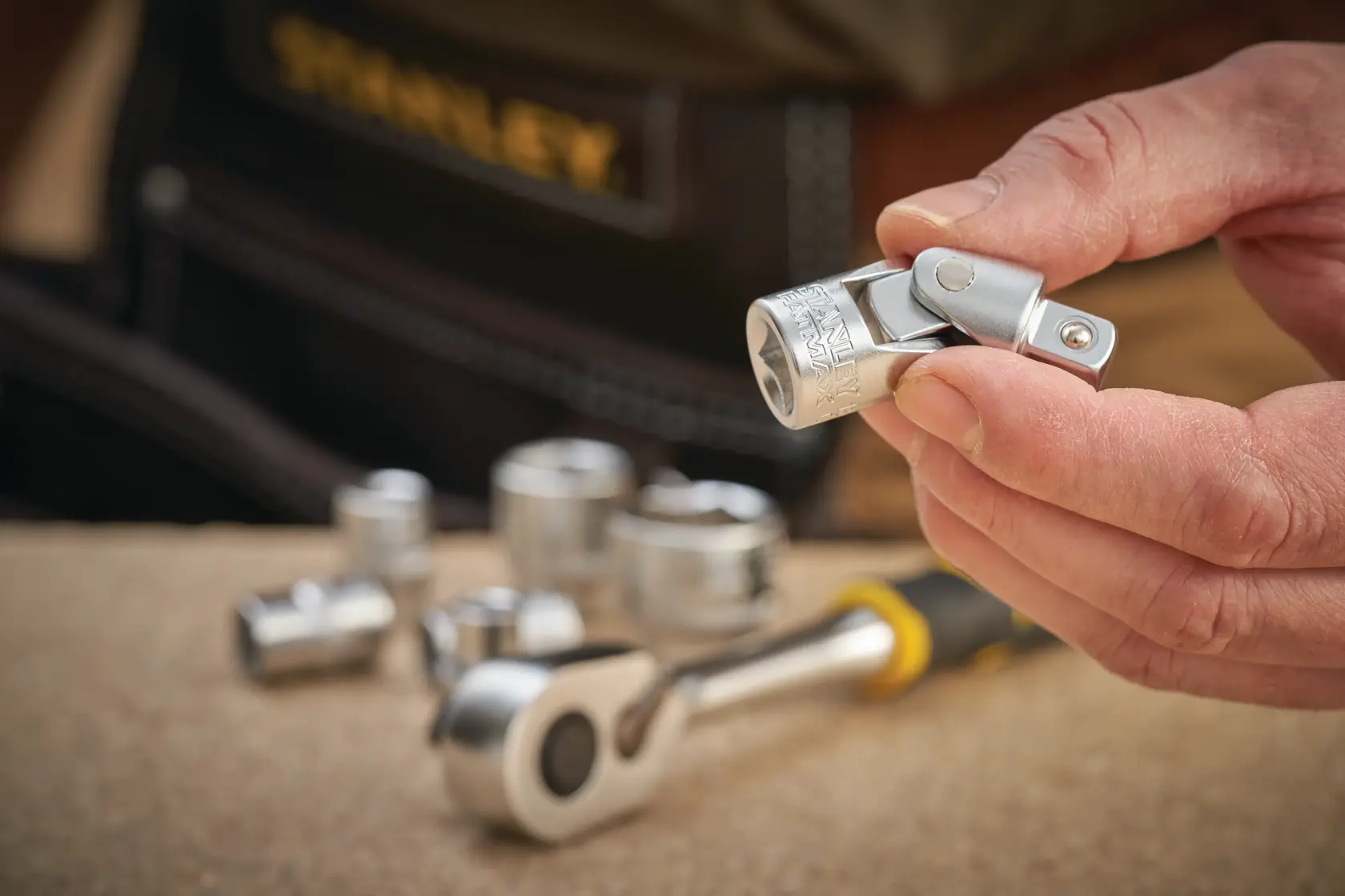 STANLEY FMMT18011-0 socket and universal joint in hand, photography of socket set tools.