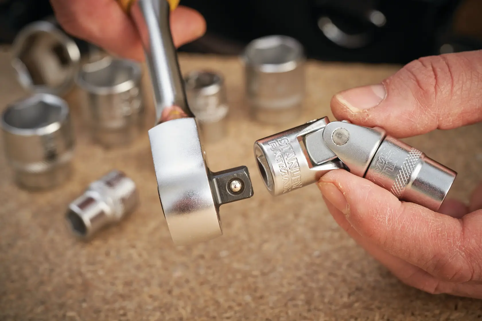 STANLEY FMMT18011-0 socket and universal joint photography, close-up, chrome finish, hand holding tool.