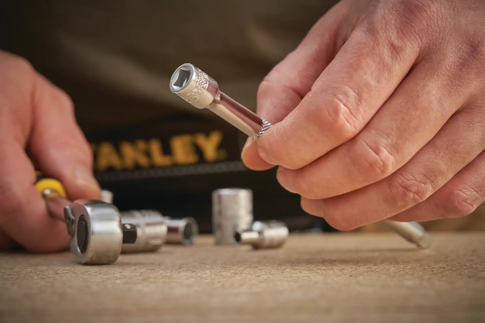 Photo of STANLEY FMMT25126-0 socket wrench set being held and used on a workbench.