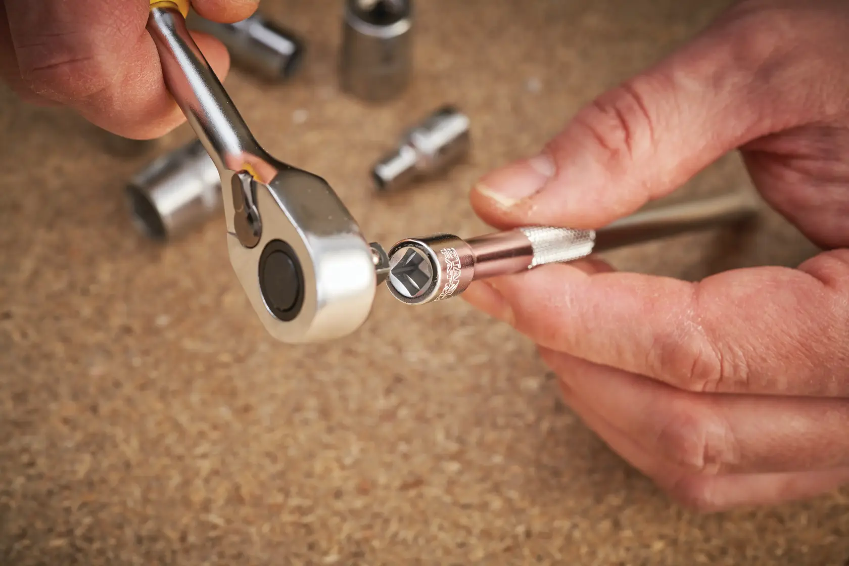STANLEY FMMT25126-0 ratchet and socket tool in use, close-up, photography on workshop table.