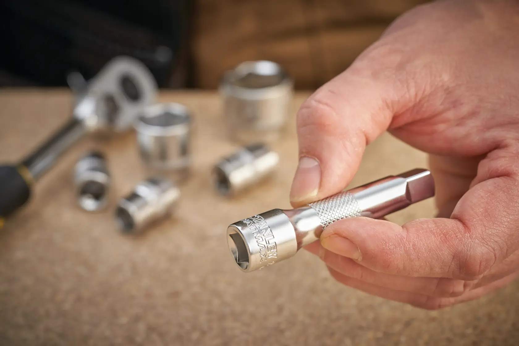 Photo of STANLEY FMMT25130-0 socket extension held in hand with sockets in background.