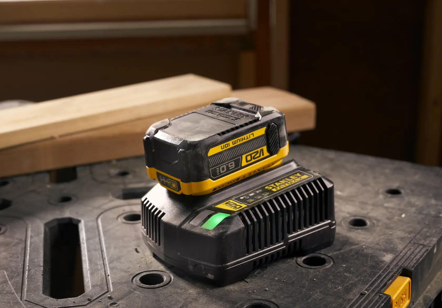 Stanley SFMCB206 lithium-ion battery and charger on a workbench, photography angled from the front side.