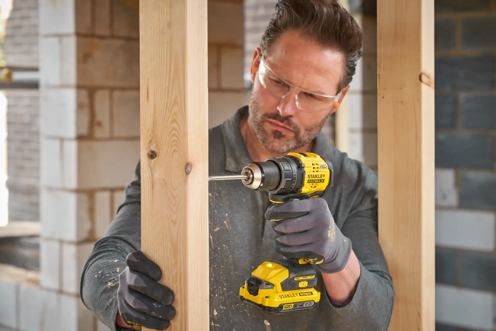 Photo of STANLEY SFMCD714D2T cordless drill being used for wood construction, product highlighted in use.