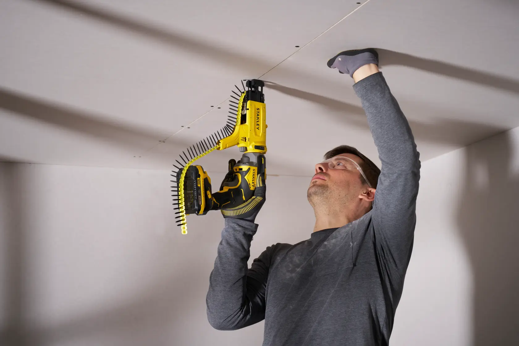 STANLEY SFMCF600D1S cordless collated screw gun used on ceiling drywall panel.